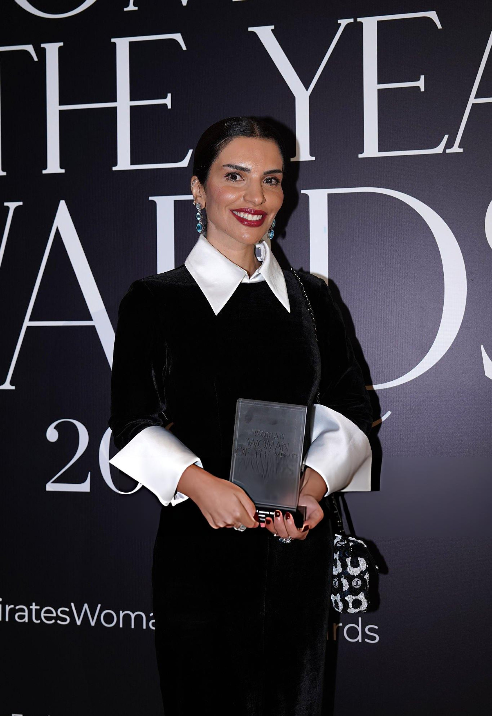 Amina Taher poses with the Woman of the Year Award for the Winter Escape Issue